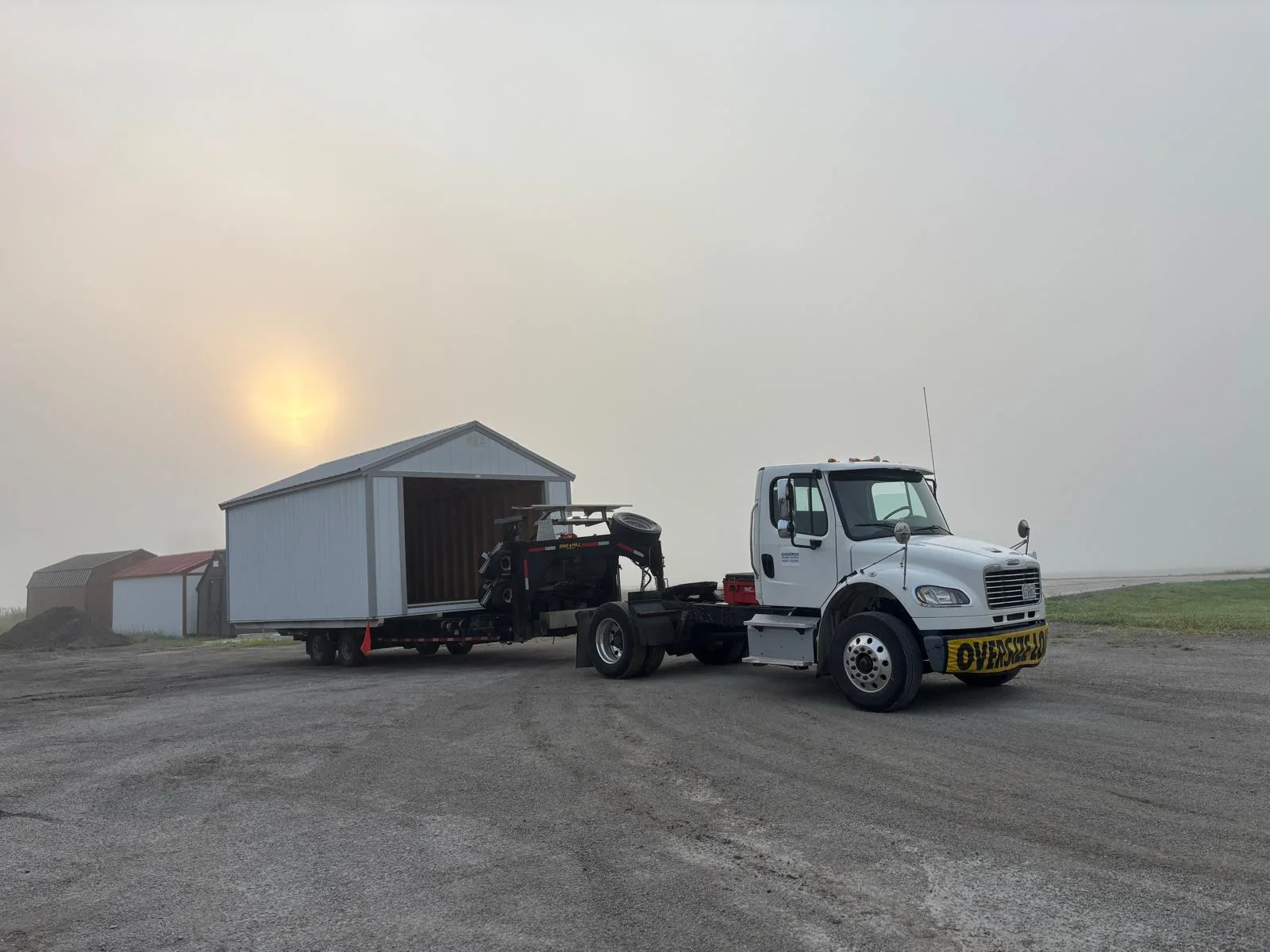 Missouri Shed Movers truck hauling a portable garage